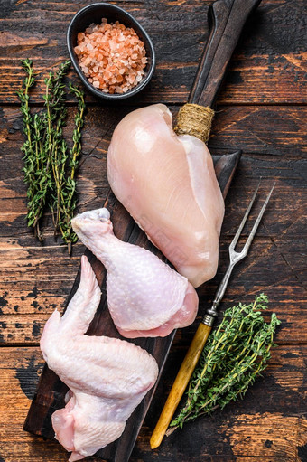 生鸡部分烹饪烧烤去皮的乳房鸡腿翅膀黑暗木背景前视图