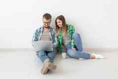 微笑年轻的夫妇使在线购买家具抵押贷款公寓在线购物概念移动PC小工具