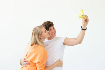有趣的疯狂的年轻的夫妇金发女郎女孩赶时髦的人的家伙采取自拍古董黄色的电影相机摆姿势白色背景概念摄影爱好