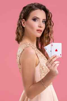 年轻的美丽的女人持有赢得结合扑克卡片粉红色的背景ace