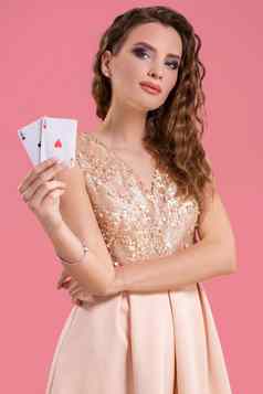 年轻的美丽的女人持有赢得结合扑克卡片粉红色的背景ace