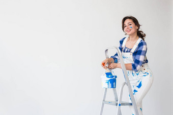 修复改造工人人概念美丽的女人站梯混合油漆白色背景复制空间