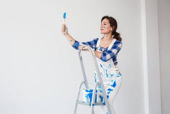 人<strong>改造</strong>工作概念美丽的女人站梯绘画墙