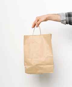男人。手格子衬衫扭曲的袖手持有棕色（的）纸袋孤立的白色背景交付概念纸袋外卖食物交付携带