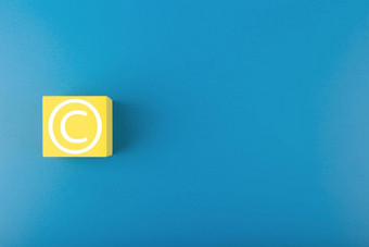 最小的蓝色的版权保护概念蓝色的背景复制空间版权象征黄色的多维数据集