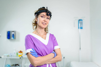 医疗工人ent诊所中间岁的高加索人女紫色的医疗统一的摆姿势相机检查房间专业医疗专家耳鼻喉科专家医院