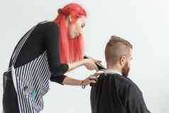 理发师设计师理发师商店概念年轻的女人发型师减少男人。