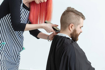 理发师发型师理发师商店概念女人发型师切割有胡子的男人。