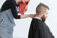 理发师设计师理发师商店概念年轻的女人发型师减少男人。
