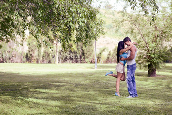 年轻的夫妇接吻美丽的公园