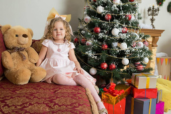 女孩坐着圣诞节树沙发泰迪熊