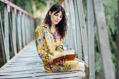 年轻的女人阅读书农村桥