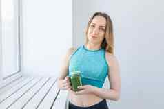 健康的饮食排毒重量损失概念年轻的女人运动服装绿色奶昔
