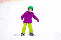 滑雪板冬天体育运动女孩学习滑雪板穿温暖的冬天衣服冬天背景