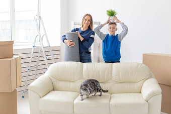 年轻的可爱的单妈妈。儿子快乐移动房子持有垂耳的苏格兰猫能绿色手概念乔迁庆宴家庭空间扩展