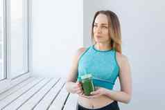 健康的饮食排毒重量损失概念年轻的女人运动服装绿色奶昔