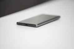 黑色的现代移动电话空白屏幕黑色的石头表格背景智能手机黑暗灰色古董纹理背景