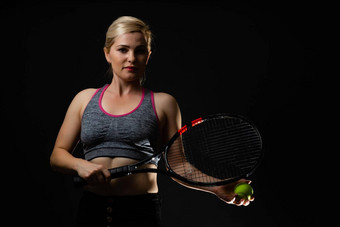 年轻的女<strong>网球</strong>球员摆姿势球拍黑色的背景