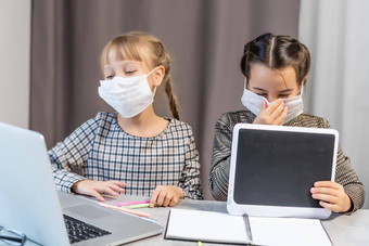 年轻的小学学校女孩脸保护面具看在线教育类冠状病毒科维德封锁教育概念