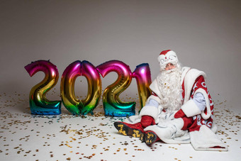 圣诞老人坐着地板上色彩鲜艳的气<strong>球形</strong>状<strong>摄影</strong>圣诞节一年广告