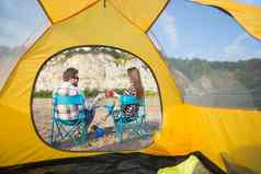 人旅游自然概念可爱的夫妇坐着黄色的帐篷