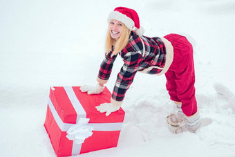 冬天女人礼物女人圣诞老人老人衣服给大红色的礼物白色雪背景快乐女人站白色雪背景持有巨大的红色的礼物盒子手