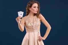 年轻的美丽的女人持有赢得结合扑克卡片黑暗蓝色的背景ace