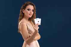 年轻的美丽的女人持有赢得结合扑克卡片黑暗蓝色的背景ace
