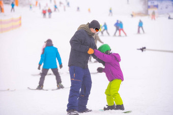 教练教孩子雪坡滑雪板