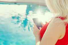 女人手智能手机游泳池