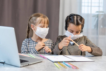 年轻的小学学校女孩脸保护面具看在线教育类冠状病毒科维德封锁教育概念