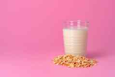 燕麦牛奶玻璃器皿干燕麦片粉红色的背景