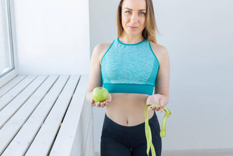 健康的生活方式饮食重量损失人概念健身女人测量磁带苹果微笑快乐相机