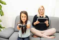 好的关系可爱的女孩年轻的妈妈。操纵杆玩视频游戏坐着生活房间享受家庭假期
