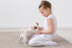 动物孩子们宠物概念孩子女孩坐着地板上可爱的小狗玩