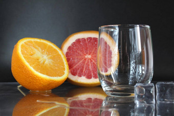 烹饪柠檬水水玻璃冰水果橙色葡萄柚黑色的背景夏天饮料柠檬水喝