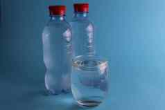 水玻璃附近的水瓶蓝色的背景很酷的软饮料夏天热清洁喝水平衡水率水消费一天