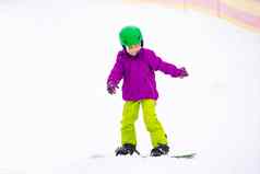 滑雪板冬天体育运动女孩学习滑雪板穿温暖的冬天衣服冬天背景