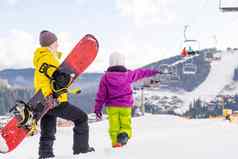 妈妈。女儿滑雪板玩雪