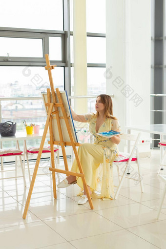 艺术学校创造力休闲概念学生女孩年轻的女人艺术家画架调色板油漆刷绘画图片工作室