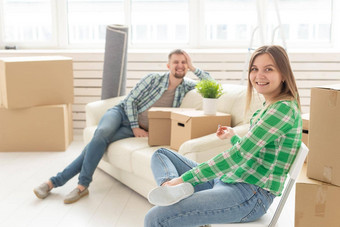 积极的快乐的夫妇喜乐移动公寓坐着生活房间物品概念乔迁庆宴抵押贷款年轻的家庭
