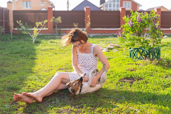 笑积极的年轻的女人衣服戏剧亲爱的不安分的狗坐着院子里国家房子阳光明媚的夏天一天家庭周末概念
