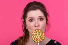 糖果上瘾甜蜜的情绪概念惊讶女人棒棒糖粉红色的背景