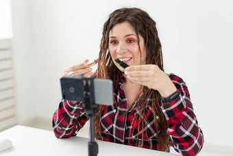 写博客视频博客化妆品概念年轻的女人博主会说话的相机黑色的口红