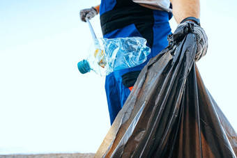 手男人。志愿者抓住<strong>塑料</strong>垃圾浪费袋清洁海滩