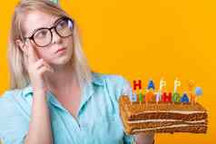 特写镜头年轻的女人纸祝贺的他持有蛋糕快乐生日站黄色的背景禧年祝贺你概念