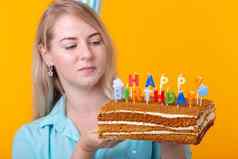 特写镜头快乐的年轻的女人纸祝贺的他持有蛋糕快乐生日站黄色的背景禧年祝贺你概念