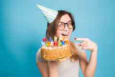 迷人的快乐疯狂的年轻的女孩学生祝贺的纸他持有快乐生日蛋糕手站蓝色的背景广告空间