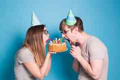 奇怪的年轻的夫妇女孩男孩纸帽子咬一块祝贺的蛋糕生日祝贺你概念