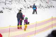 游客享受玩滑雪滑雪板滑雪度假胜地假期